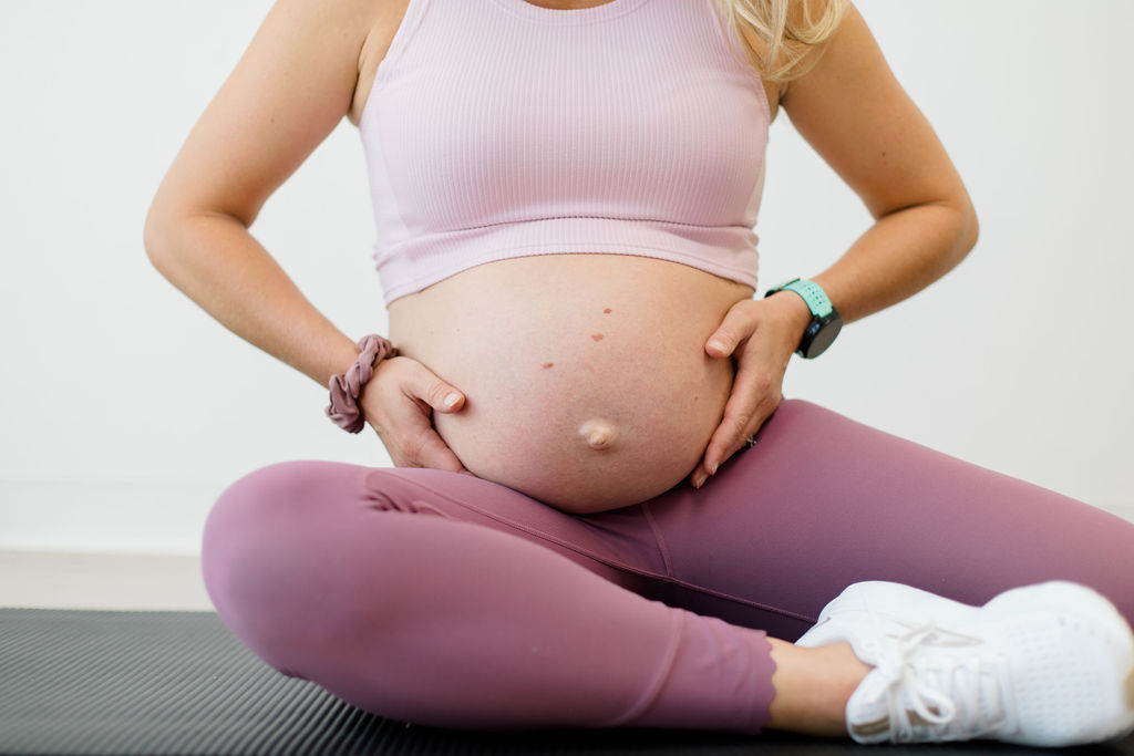 A pregnant woman holding her belly, learn how to relieve pelvic pain during pregnancy!