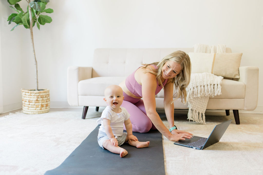 Woman doing physical therapy online with baby by her side.