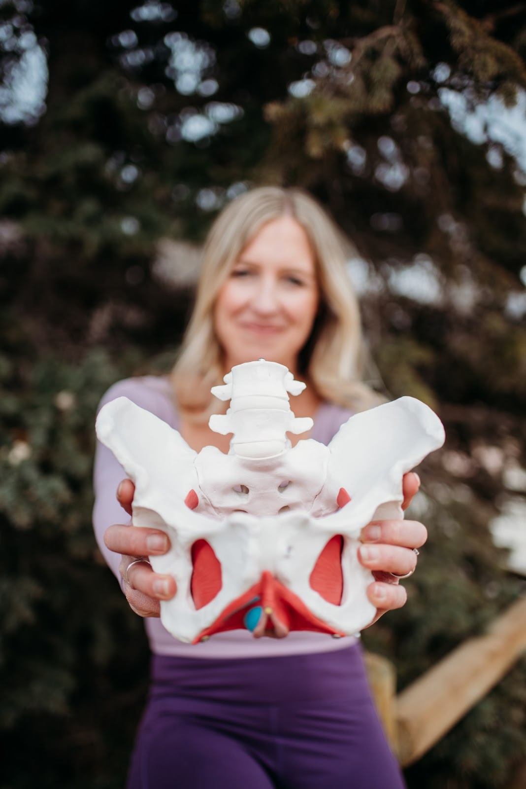 Pelvic floor therapist, Anna Towne, holding a pelvic floor mockup. She explains how to tell if pelvic floor is tight or weak.
