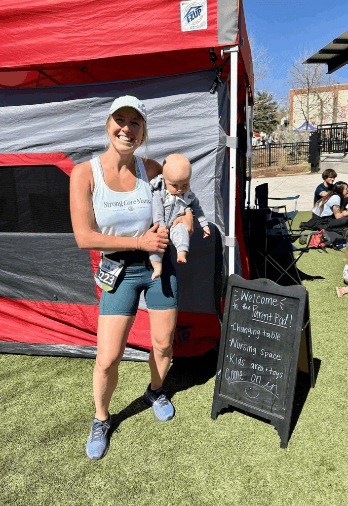 Mom finishing up a race holding her baby, she was running while breastfeeding. 