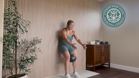 Standing wall reach with ball exercise.